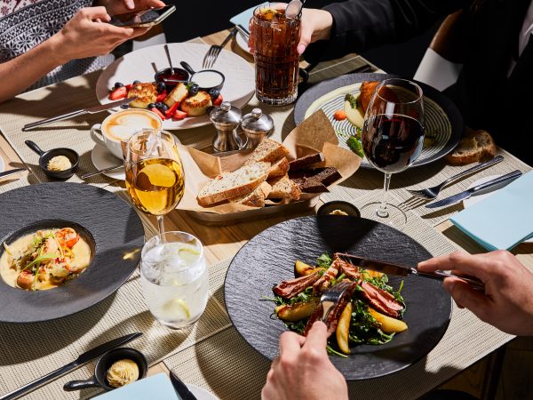 cropped view of people eating delicious food in restaurant cropped view of people eating delicious food in restaurant