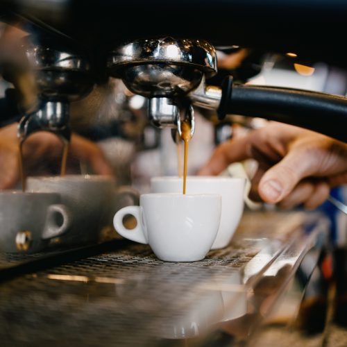 Close up shot of experienced barman or bartender hands making delicious and fresh espresso coffee drink on machine. Close up shot of experienced barman or bartender hands making delicious and fresh espresso coffee drink on machine.